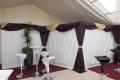 Pole Drape with ivory starlight walling and aubergine and gold queen swags and drapes